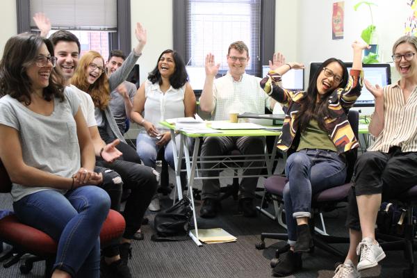 People smiling and laughing wiht hands in the air