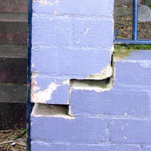 Cracked purple brick wall