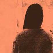 A woman with long black hair - her face is turned away from the camera
