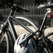 Black bike out the front of a building in the sun