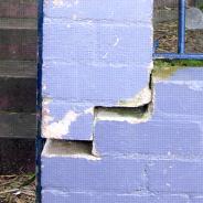 Cracked purple brick wall