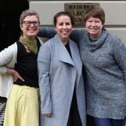 Three woman with their arms around each other standing outside Redfern Legal Centre