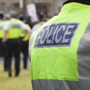 Group of officers wearing yellow and blue hi vis gear which reads 'Police' on back