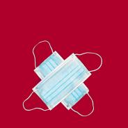 Two blue COVID masks lying in cross formation against a red background