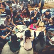Overhead view of a large group of students studying at desk.
