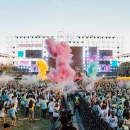 Large crowd at music festival colourful smoke is blowing over the crowd