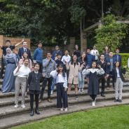 Group of international students standing outside on a set of stairs in an ampitheatre